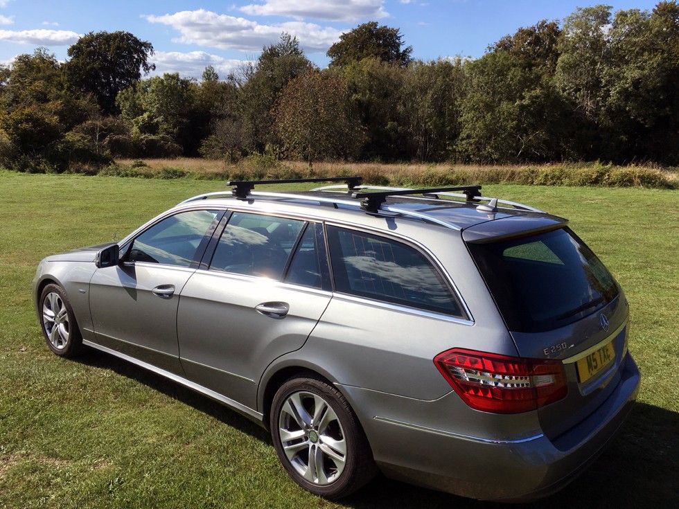 Silver Mercedes-Benz E-Class estate fitted with roof bars